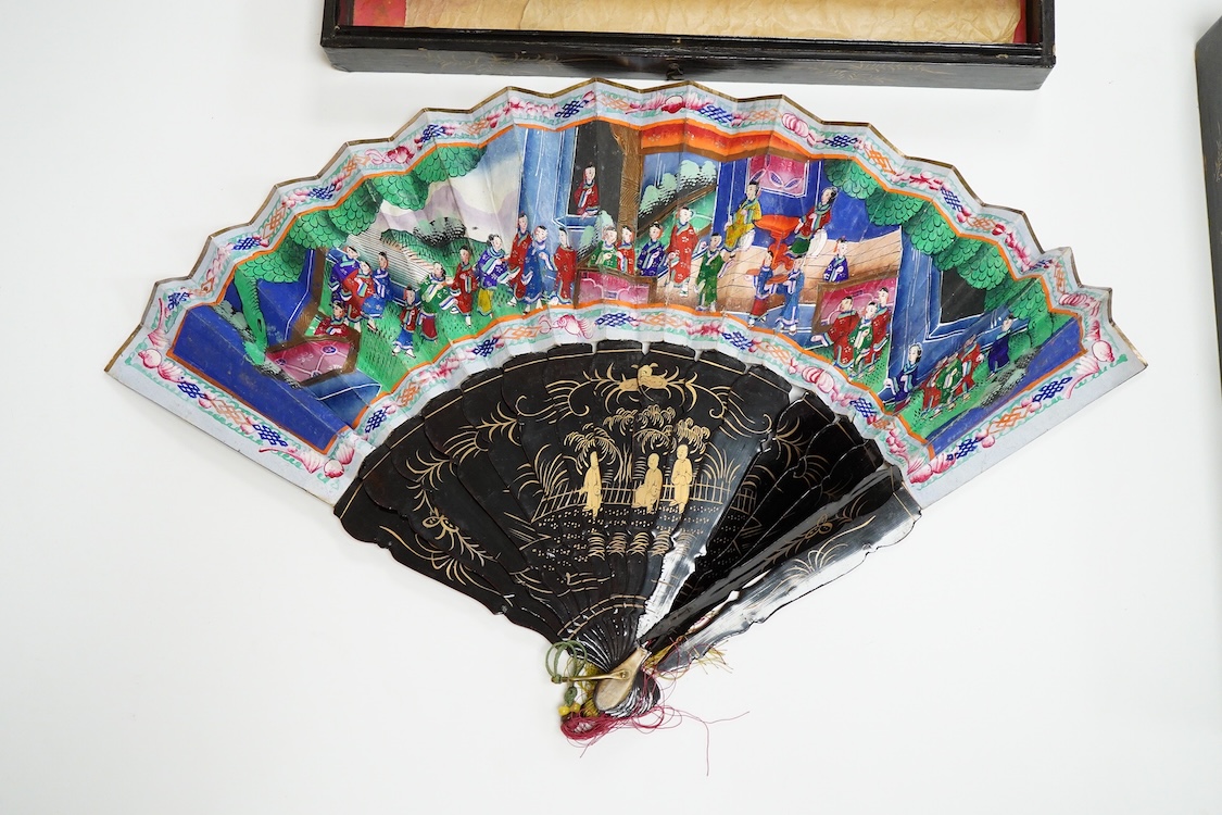 Four 19th century Chinese gilt-decorated black lacquer fans with figure painted leaves, two cased, largest 41cm